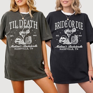 Peut inclure: Deux t-shirts noirs avec du texte et des graphismes blancs. Le premier t-shirt dit "Til Death do us party" avec un cr&acirc;ne et des os crois&eacute;s et deux cocktails. Le deuxi&egrave;me t-shirt dit "Bride or Die" avec un cr&acirc;ne et des os crois&eacute;s et deux cocktails. Les deux t-shirts disent "Madison's Bachelorette Nashville, TN" et "Est. 2025".