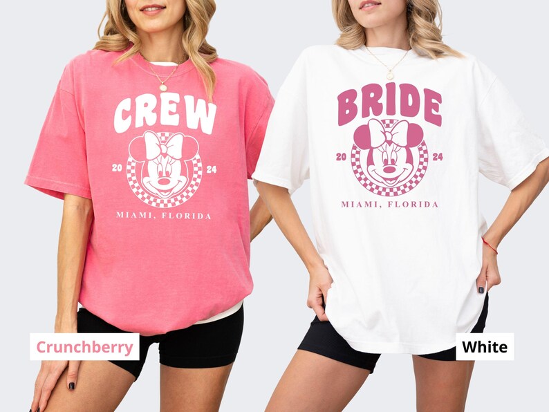 Puede incluir: Dos camisetas rosa y blancas con un gr&aacute;fico de un rat&oacute;n de dibujos animados con un lazo. La camiseta rosa dice "CREW" y la camiseta blanca dice "BRIDE". Ambas camisetas dicen "2024 MIAMI, FLORIDA".