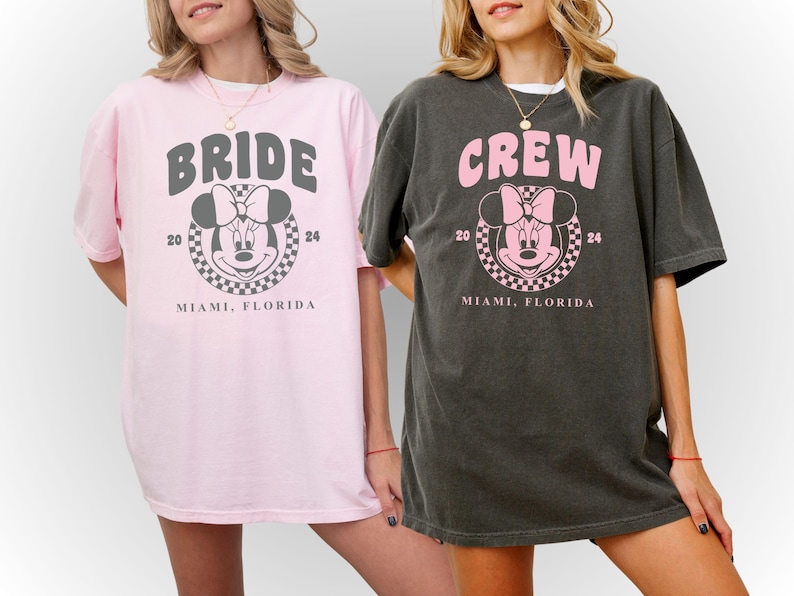 Puede incluir: Dos camisetas de color rosa y gris con un gr&aacute;fico inspirado en Mickey Mouse. Una camiseta dice "Bride" y la otra dice "Crew". Ambas camisetas dicen "Miami, Florida" y "20 24" debajo del gr&aacute;fico.