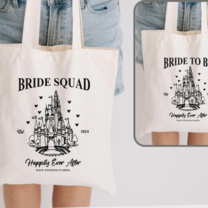 May include: White canvas tote bag with black text and a black outline of Cinderella's castle. The text reads "Bride Squad" and "Happily Ever After" with the year 2024.