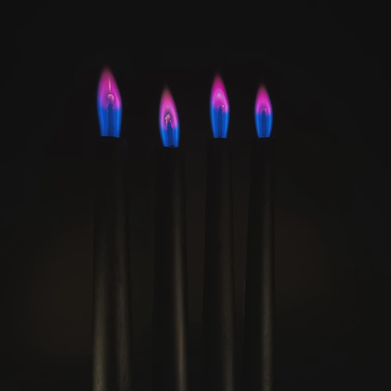 Close-up of romantic pink flame candles producing vivid pink flames, handmade for science fans, witches, and love manifestation.