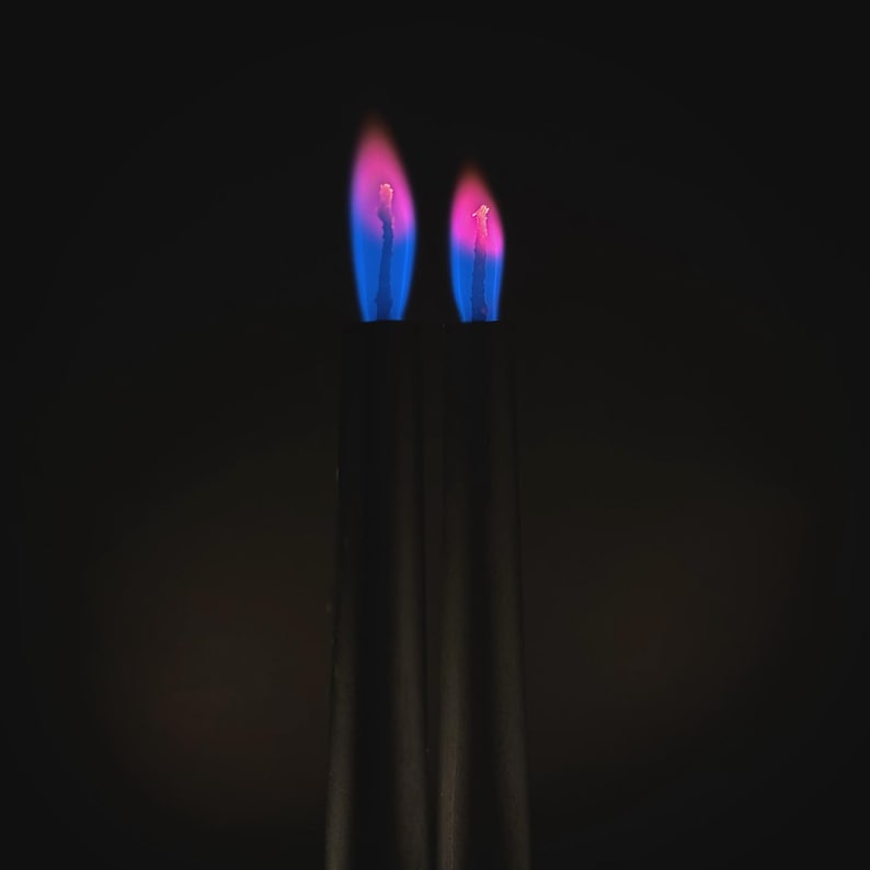 Close-up of romantic pink flame candles producing vivid pink flames, handmade for science fans, witches, and love manifestation.
