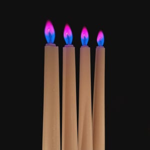 Close-up of romantic pink flame candles producing vivid pink flames, handmade for science fans, witches, and love manifestation.