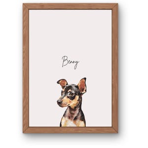 Pode incluir: Uma impressão artística emoldurada com uma ilustração estilizada de um cão preto e castanho com orelhas pontiagudas. O nome Benny está escrito em letra cursiva preta acima do cão. A obra está numa moldura de madeira clara.