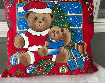 May include: Red Christmas pillow with two teddy bears, one dressed as Santa Claus, holding a Christmas tree and presents. The pillow reads "Merry Christmas" and "Best Wishes".