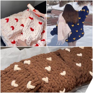 Peut inclure: Trois couvertures au crochet avec des détails en forme de cœur. Une couverture est blanche avec des cœurs rouges, une autre est marron avec des cœurs blancs et la dernière est bleue avec des cœurs jaunes.