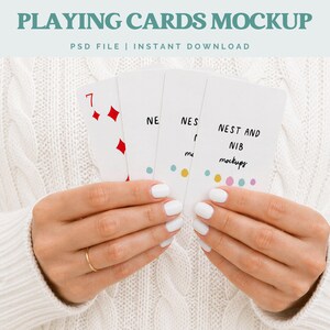 May include: A person holding a mockup of playing cards. The cards are white with red diamond suit symbols and the number 7. The text "PLAYING CARDS MOCKUP" and "NEST AND NIB mockups" are visible.