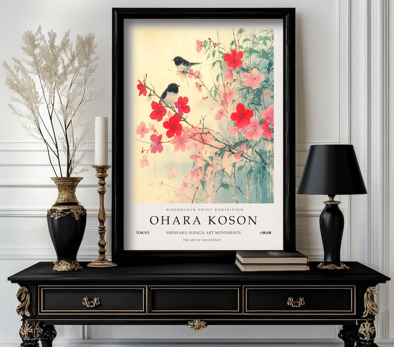 May include: A black framed print of a Japanese woodblock print featuring two black and white birds perched on a branch of pink and red blossoms. The print is titled "Ohara Koson" and includes the text "Woodblock Print Exhibition, Tokyo, Shinsaku-Hanga Art Movements, The Art of 20th Century".