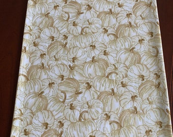 May include: White table runner with a brown and white pumpkin pattern. The pumpkins are drawn in a detailed, almost sketched style.