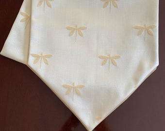 May include: A white table runner with a gold embroidered dragonfly design and a gold tassel.