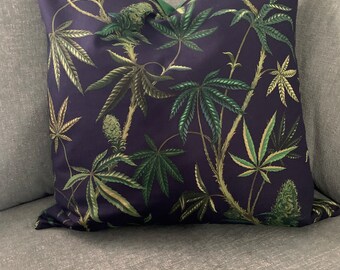 May include: A dark blue throw pillow with a green leafy pattern. The pillow is made of a soft, comfortable fabric and features a unique design.