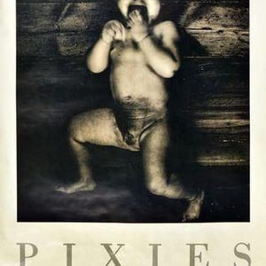 May include: Monochrome poster showing a crying baby against a wooden backdrop. The word "PIXIES" is at the bottom, with text detailing a London Town and Country Club concert.