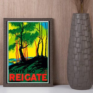 May include: A framed vintage travel poster for Route 160 Reigate. The poster features a stylized landscape with green trees, red tree trunks, and a yellow and blue sky. The text "ROUTE 160 REIGATE" is in red.
