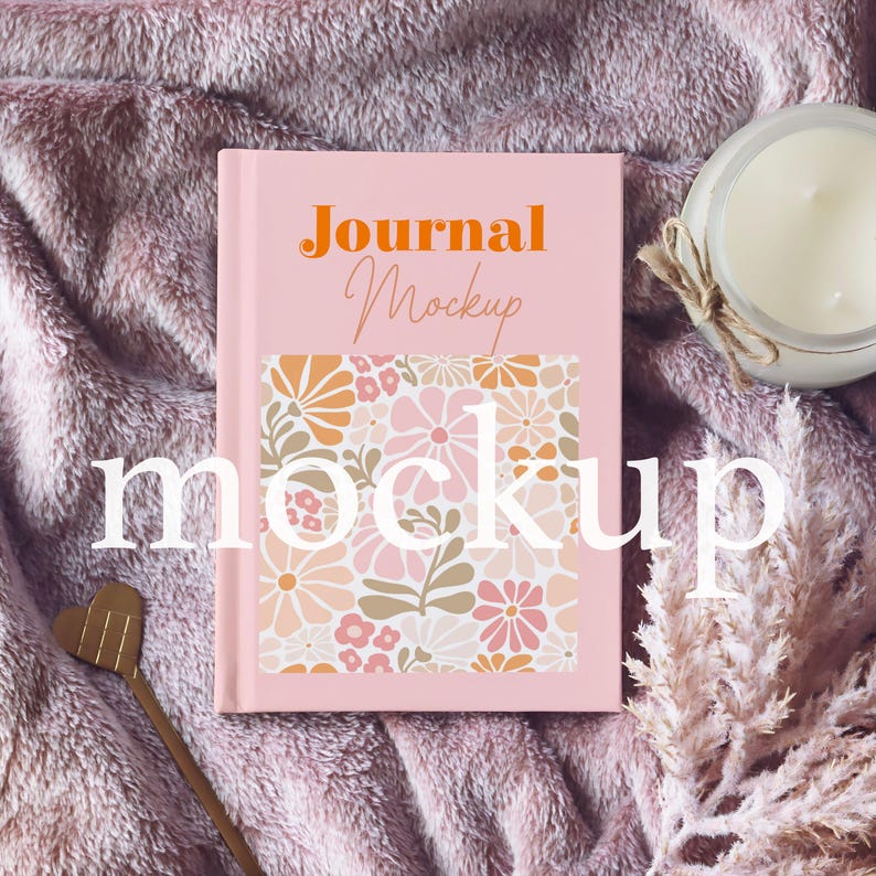 May include: Pink journal mockup with a floral pattern on the cover. The text "Journal Mockup" is printed in orange on the cover.