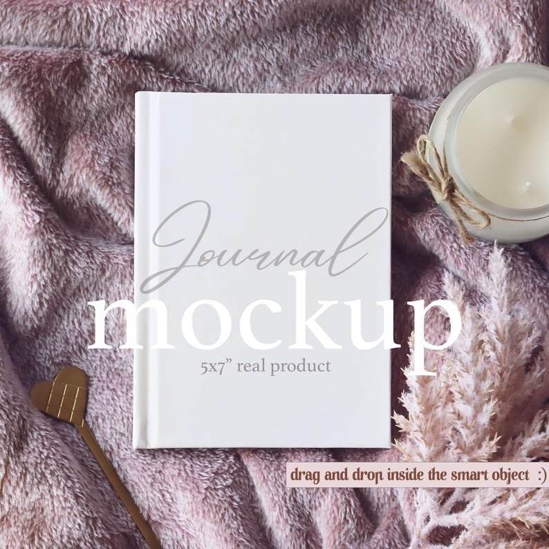 May include: White journal mockup with the text "Journal mockup 5x7" real product" on a pink fuzzy blanket with a candle and dried flowers.