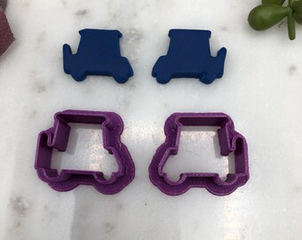 Può includere: Due set di stampini per biscotti a forma di golf cart. Un set è blu e l'altro è viola.