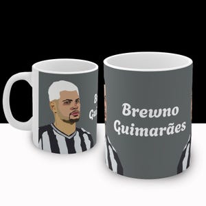 Puede incluir: Taza de cer&aacute;mica blanca con una ilustraci&oacute;n en blanco y negro de un jugador de f&uacute;tbol en un lado y el texto "Brewno Guimar&atilde;es" en el otro.