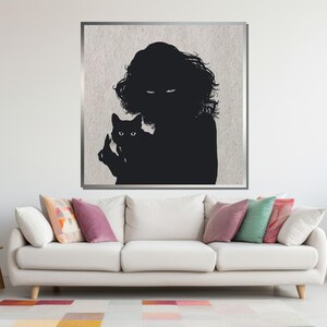 Puede incluir: Una ilustraci&oacute;n en blanco y negro de una persona sosteniendo un gato. La persona tiene el pelo largo y lleva un vestido oscuro. El gato mira hacia la izquierda. La ilustraci&oacute;n est&aacute; sobre un fondo gris claro.