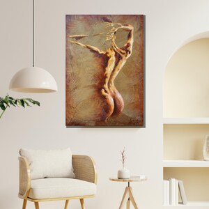 以下が含まれることがあります： 金色と茶色の色合いで描かれたヌードの女性の絵画。女性は背を向けて立ち、両手を頭上に上げています。背景はテクスチャのある抽象的なパターンです。