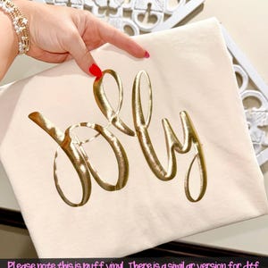 May include: Cream-colored t-shirt with the word "July" in gold, puffy vinyl lettering. The image includes the text: "Please note this is puff vinyl. There is a similar version for dtf and a blank version for you to change the colors for dtf, sublimation, ect."