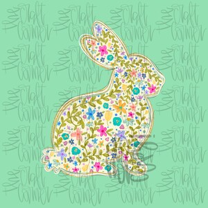 May include: A floral bunny design with a gold outline, filled with colorful flowers and green leaves. The bunny is set against a light green background with the words "Craft Corner" repeated in a pattern.