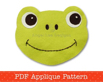 May include: A green frog face applique pattern in PDF format. The frog has large white eyes with brown pupils and a stitched smile.