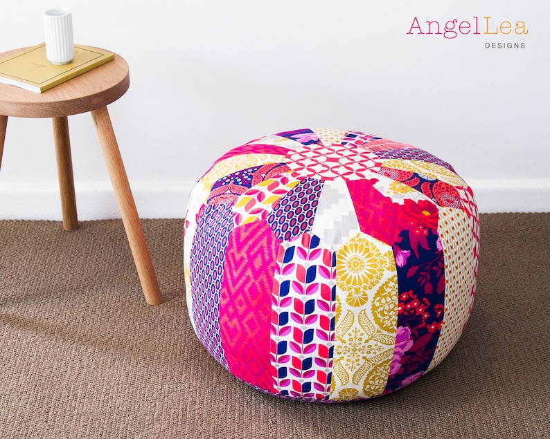 May include: A round, multi-colored patchwork ottoman with a variety of floral and geometric patterns in pink, yellow, white, blue, and purple.