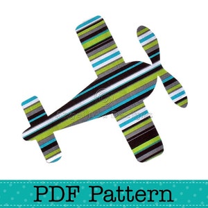 Puede incluir: Un patrón PDF para una aplicación de avión a rayas. El avión es negro, verde y azul con una hélice.