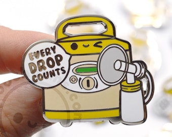 May include: Yellow enamel pin of a breast pump with a smiling face and the text "Every Drop Counts".