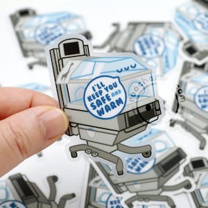 May include: A clear sticker with a cartoon illustration of a medical incubator. The incubator is white with blue accents and has a speech bubble that says "I'll keep you safe and warm".