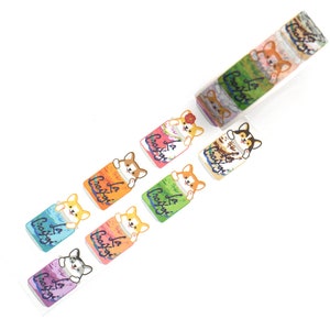 May include: A roll of washi tape featuring a repeating pattern of colorful cans with a cartoon corgi dog peeking out of each can. The text on the cans reads "La Croix".