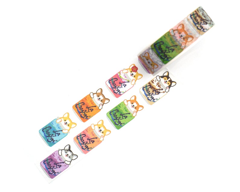 May include: A roll of washi tape featuring a repeating pattern of colorful cans with a cartoon corgi dog peeking out of each can. The text on the cans reads "La Croix".