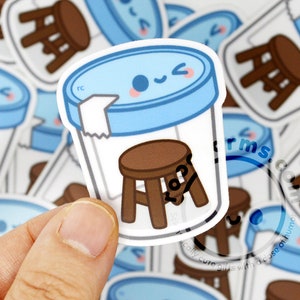 May include: A sticker featuring a cartoon illustration of a blue jar with a lid and a brown stool inside. The jar has a cute face with a wink and a smile. The sticker has a white background.