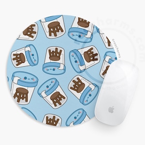 May include: A round mousepad with a light blue background featuring a repeating pattern of cartoon-style stools inside of a blue and white container. A white Apple mouse is next to the mousepad.