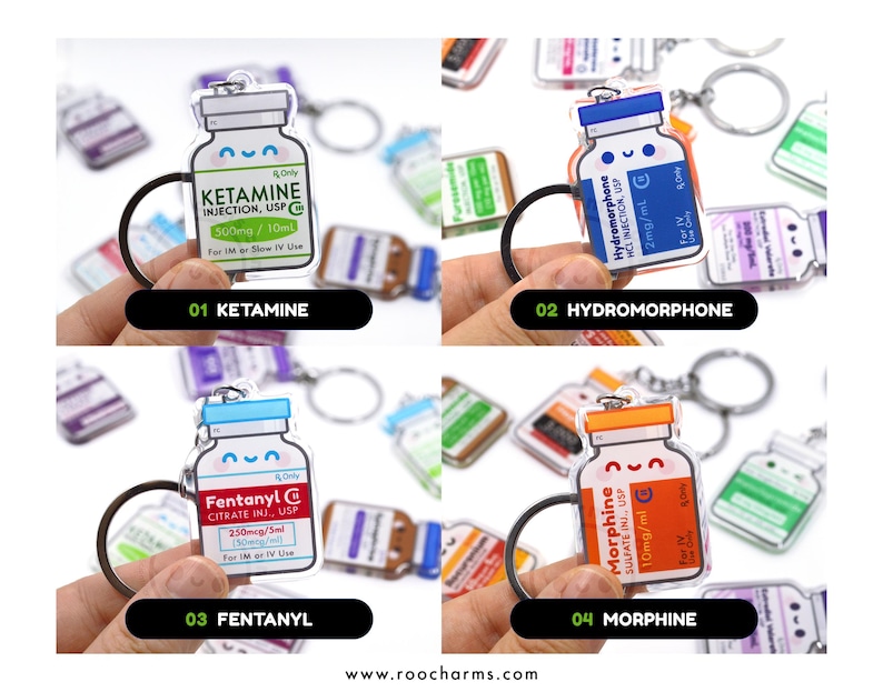 May include: A collection of four acrylic keychains shaped like medicine bottles, each with a different label: Ketamine, Hydromorphone, Fentanyl, and Morphine. The keychains have black key rings and are held against a blurred background.
