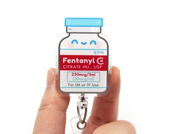 May include: A badge reel featuring a rectangular medical vial graphic with a blue cap and a smiling face. The label reads Fentanyl Citrate Inj., USP, 250mcg/5ml (50mcg/ml), Rx Only, and For IM or IV Use. The design includes a metal clip attachment.