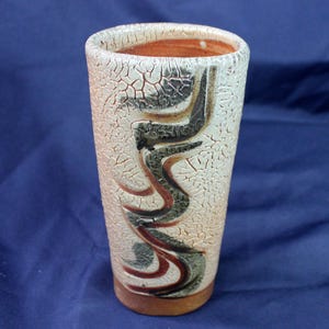 May include: A white ceramic vase with a crackled glaze and brown, black, and green abstract designs.