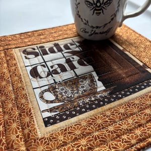 May include: A set of three ceramic mugs with a speckled, matte finish. The mugs are in shades of cream, light brown, and dark brown. Each mug has a simple, minimalist design, perfect for coffee or tea.