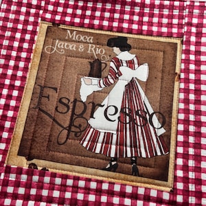 May include: A quilted placemat with a red and white gingham border. The center features a vintage-style image of a woman in a striped dress holding a coffee pot, with the word "Espresso" and "Moca Java & Rio" printed on it.