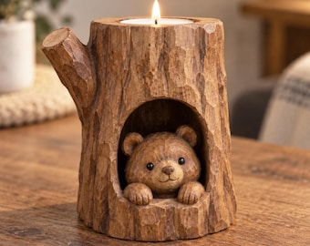 May include: A brown tree stump candle holder with a textured bark finish and a small branch protrusion on the side. A carved bear figure is nestled inside a hollow opening at the base. A lit white tea light candle sits in the top circular cavity.