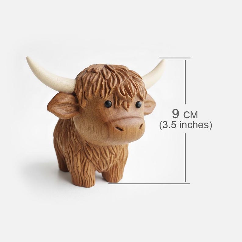 May include: A wooden Highland cow figurine, 3.5 inches tall, with detailed carving. The brown cow has a shaggy coat, small black eyes, and cream-colored horns. A charming decorative item.