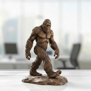 May include: A brown, textured figurine of a bipedal creature covered in fur, depicted in a walking pose. The figure features a defined facial structure, muscular chest, and long arms, standing on a base that mimics a rocky or uneven ground surface.