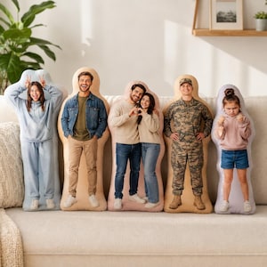 May include: Five custom-shaped pillows featuring full-body photographic prints of individuals. The pillows display a person in a blue hoodie, a person in a denim jacket, a couple, a person in a military uniform, and a child in a pink hoodie.