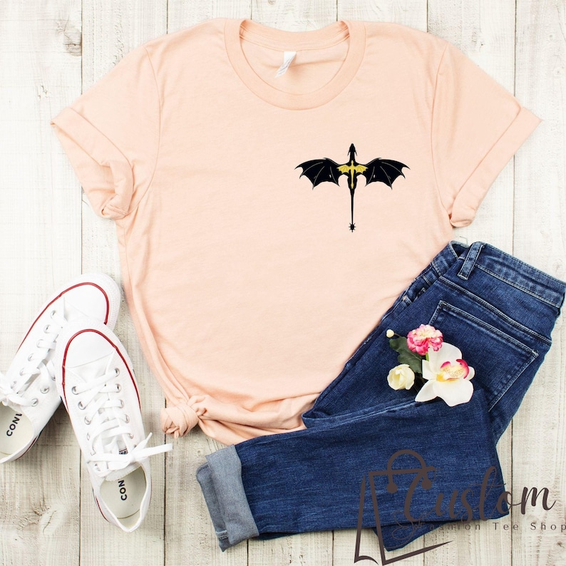 a t - shirt with a bat on it next to a pair of jeans