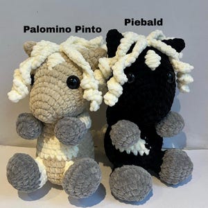 May include: Two crocheted horse plushies, one tan and cream, the other black and white. Both have fluffy cream-colored manes and gray hooves. The text "Palomino Pinto" and "Piebald" are above each horse.