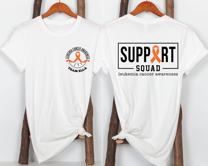 Puede incluir: Una camiseta blanca con un peque&ntilde;o logotipo circular en la parte delantera con una cinta naranja y el texto LEUKEMIA CANCER AWARENESS TEAM ELLA. La parte trasera muestra un gr&aacute;fico rectangular grande con el texto SUPPORT SQUAD y leukemia cancer awareness.