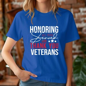 May include: A royal blue t-shirt with a white graphic that says "Honoring All Who Served Thank You Veterans". The graphic also includes a red, white, and blue American flag and stars.