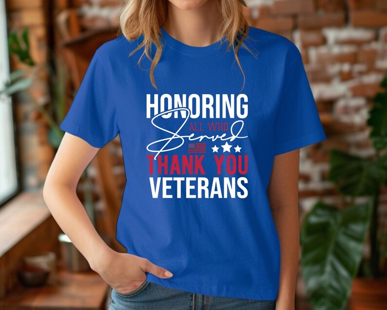 May include: A royal blue t-shirt with a white graphic that says "Honoring All Who Served Thank You Veterans". The graphic also includes a red, white, and blue American flag and stars.