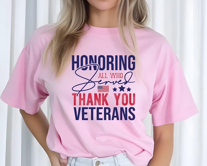 May include: Pink t-shirt with a blue and red graphic that says "Honoring All Who Served Thank You Veterans" with a small American flag and stars.