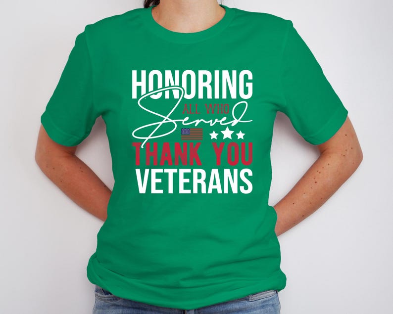May include: A green t-shirt with the text "Honoring All Who Served Thank You Veterans" in white and red lettering. The text is stylized with a white cursive "Served" and a small American flag.